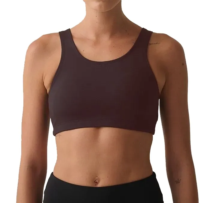 Modelo feminino usando top de treinamento FILA Essential II na cor chocolate, vista frontal com logo branco no peito